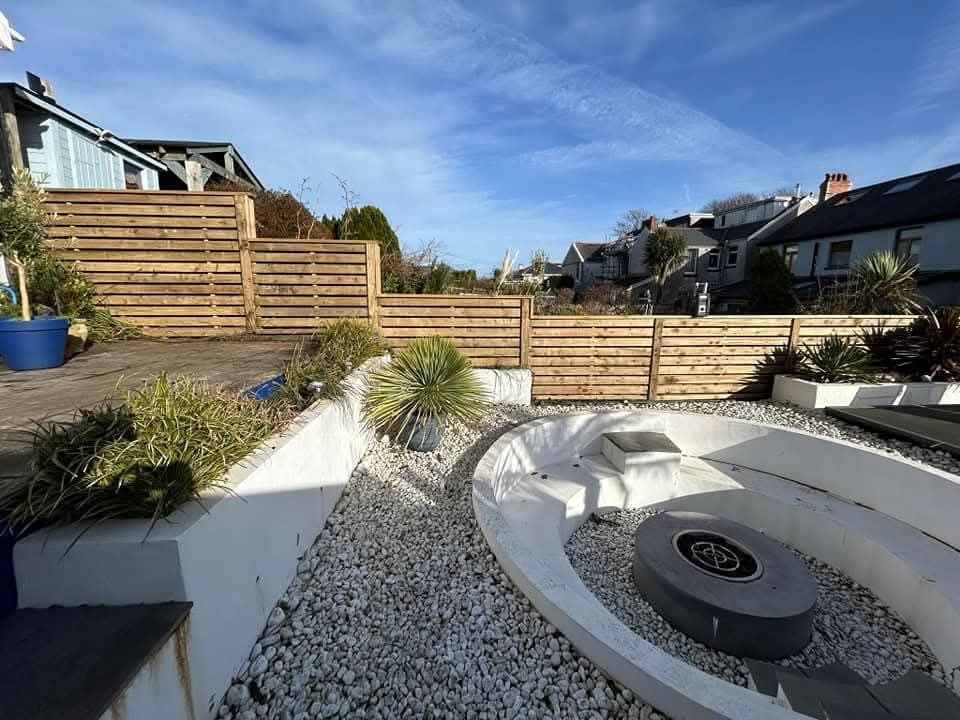 Horizontal timber slat fencing along a garden boundary with raised beds